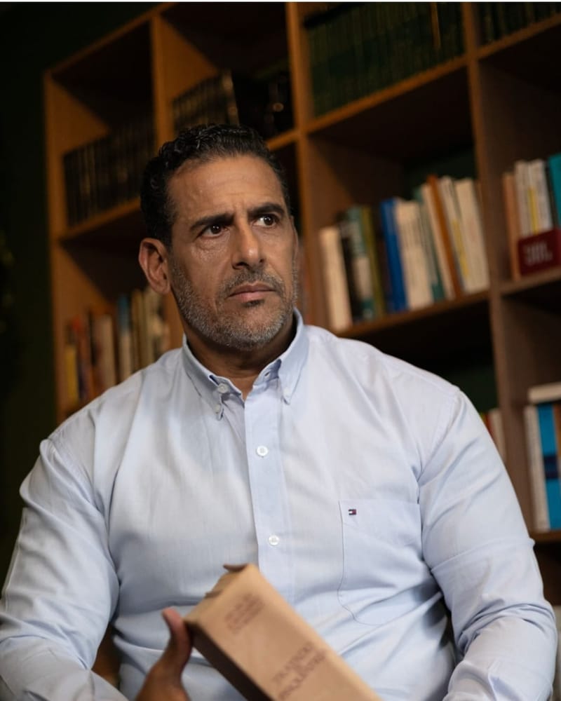 Retrato de Maurício Henriques Damasceno em seu consultório, diante de uma estante de livros